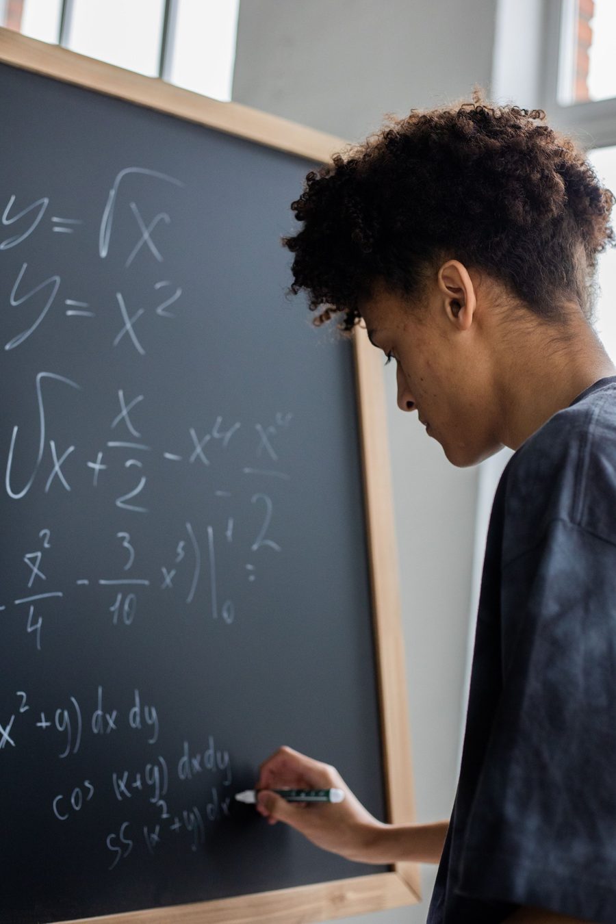 A student writing calculus on a chalkboard